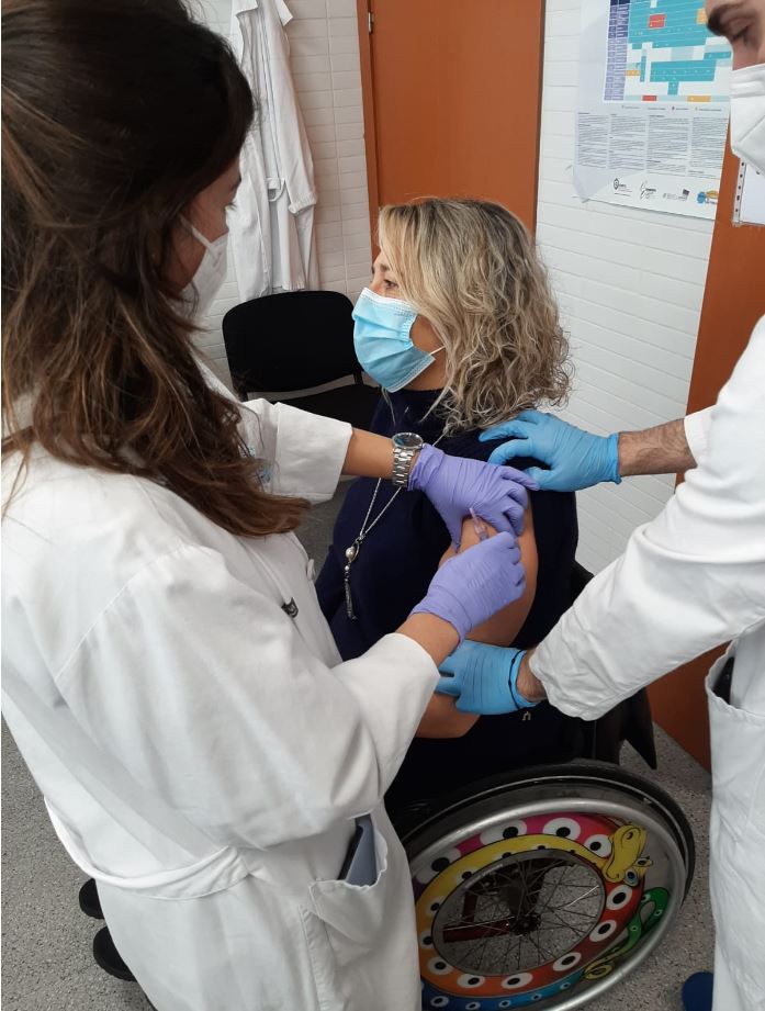 Una mujer en silla de ruedas recibe la vacuna