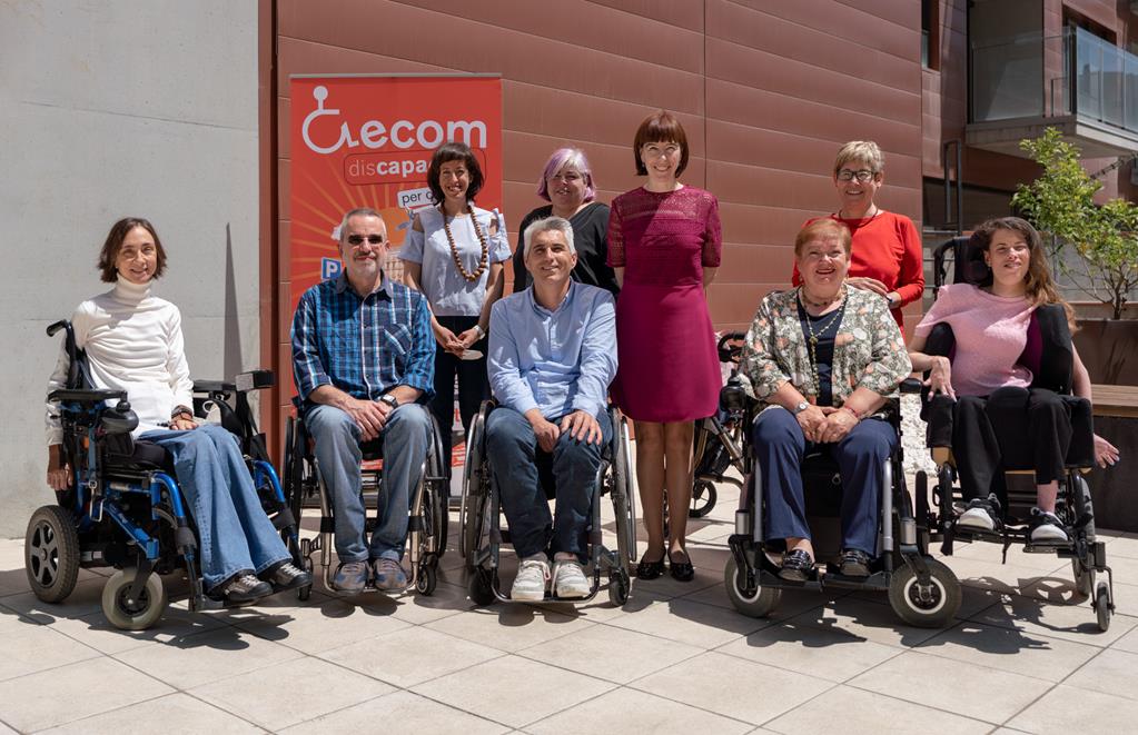 Foto de familia de la nueva Junta Directiva de la Federación ECOM en en un exterior con un roll-up de la entidad de fondo.
