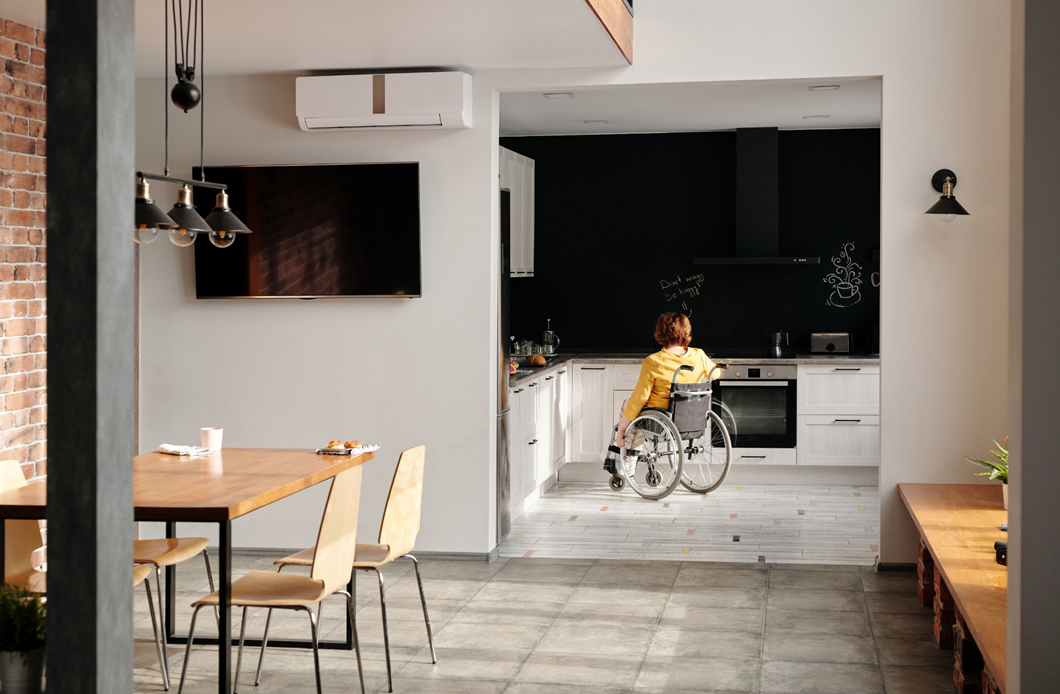 Una mujer en silla de ruedas en el interior de una vivienda, en la cocina