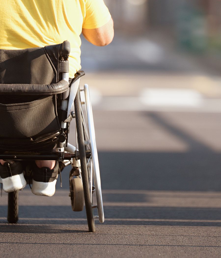 persona en silla de ruedas por una carretera libre de barreras